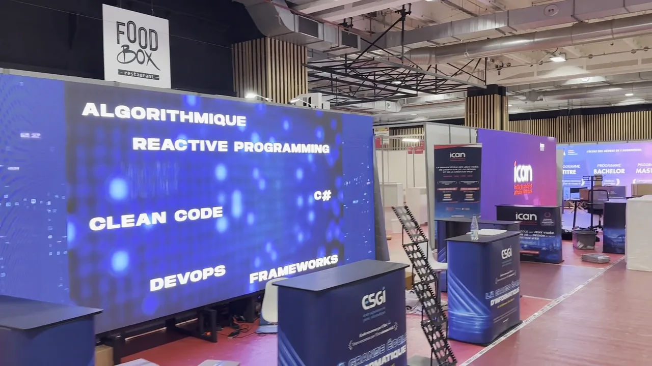Large LED wall on a stand in a trade fair hall, programming keywords on screen