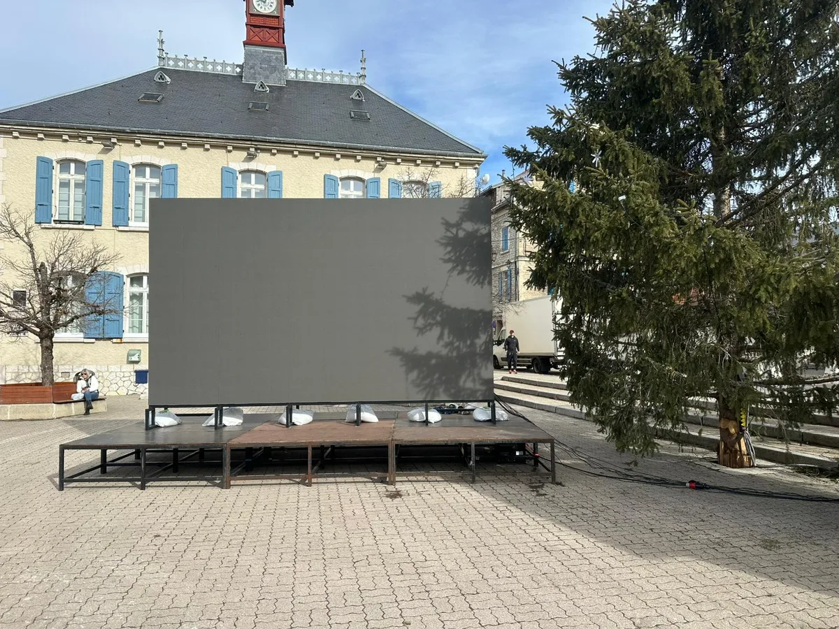 Un écran sur scène. Extérieur, écran LED de location, place de village, Suisse.