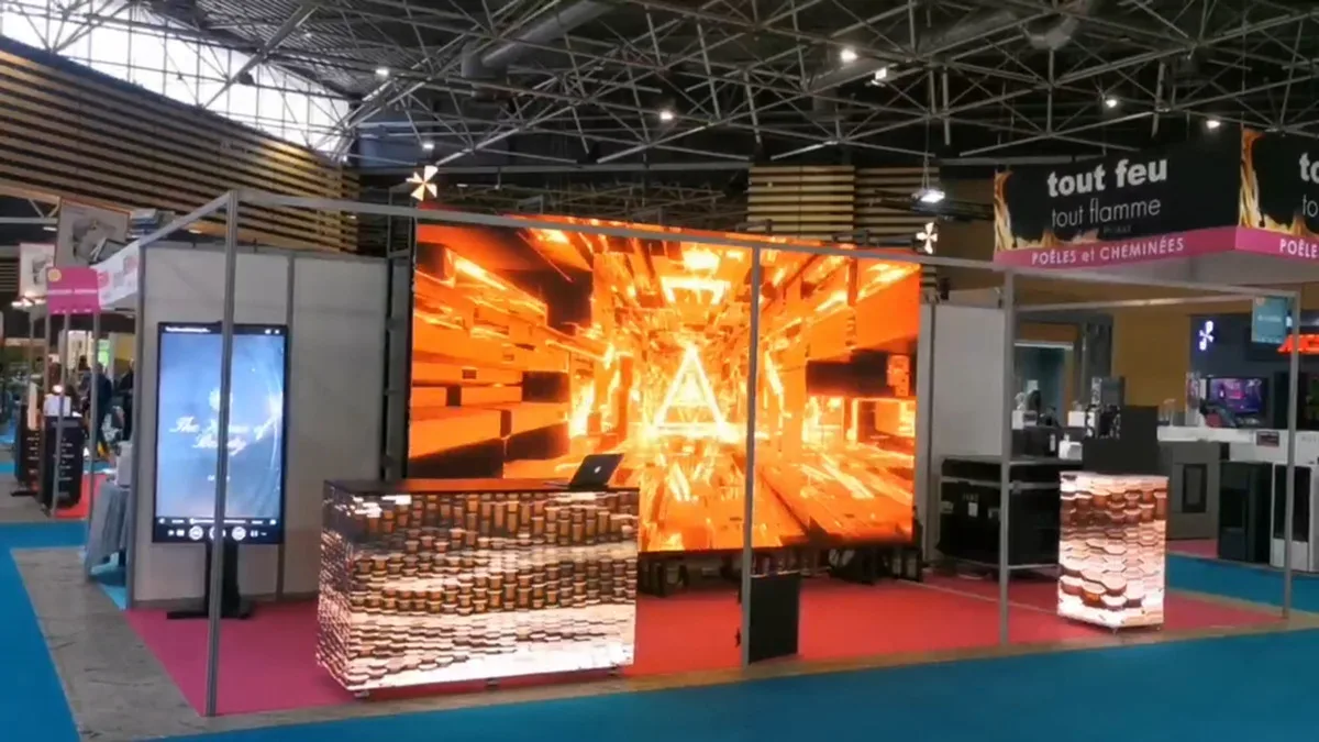 Exhibition stand with a large LED wall and LED counters, visitors in the aisle