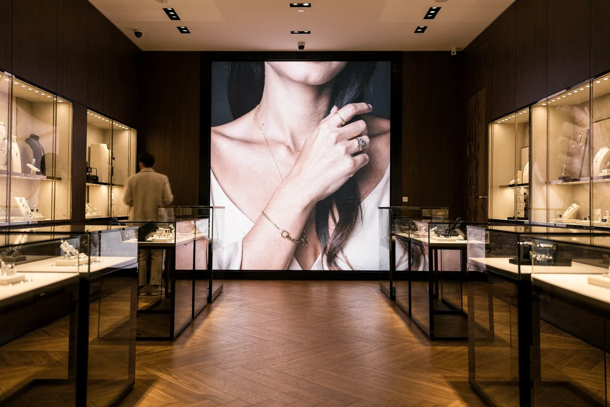 Jewellery boutique with a large LED screen on its back wall between lit display cases