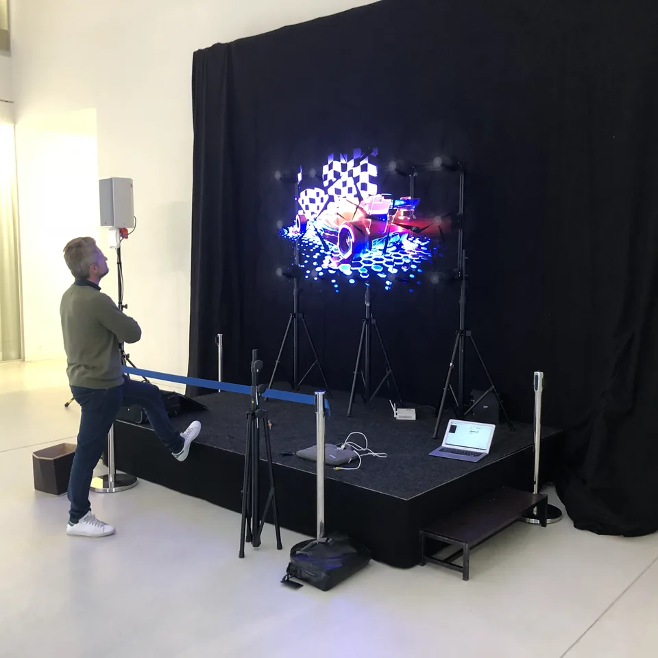 Wall of HYPERVSN fans on a stage forming one picture, a man looking up at it