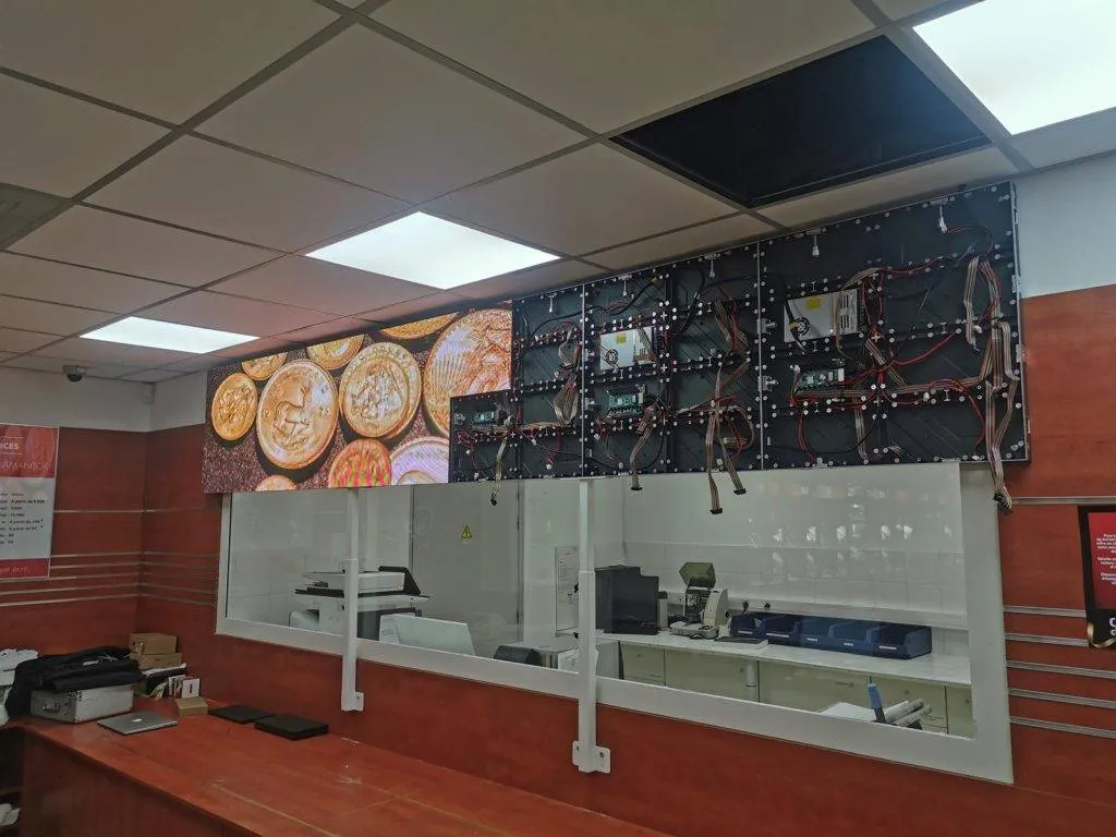 Fine-pitch LED wall set into the fit-out of a gold shop, used as a commercial banner