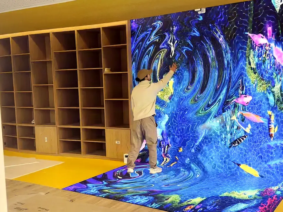 Interactive LED floor and wall forming a corner, one picture running across both