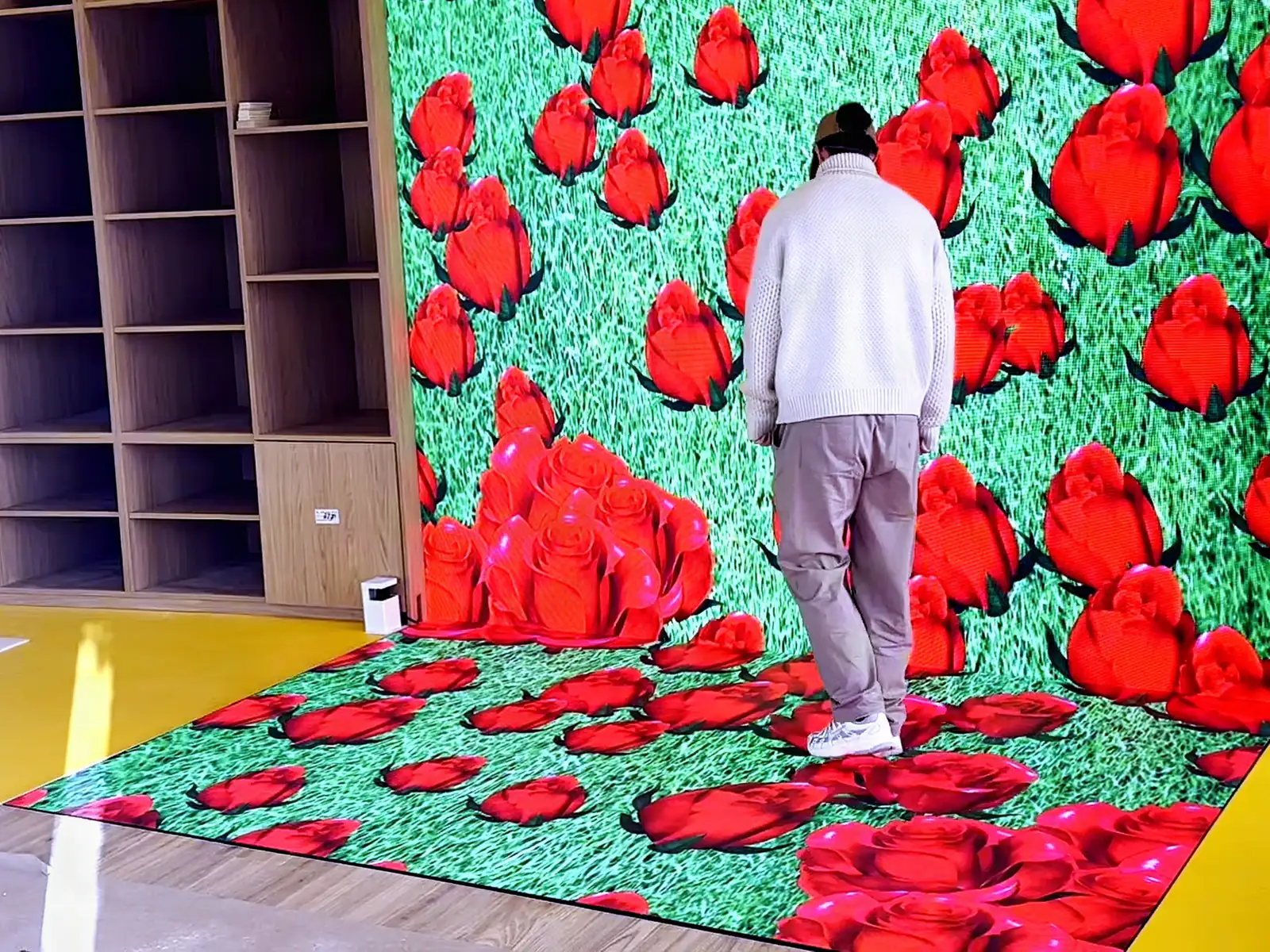 Interactive LED floor showing a field of red roses under the feet of a visitor