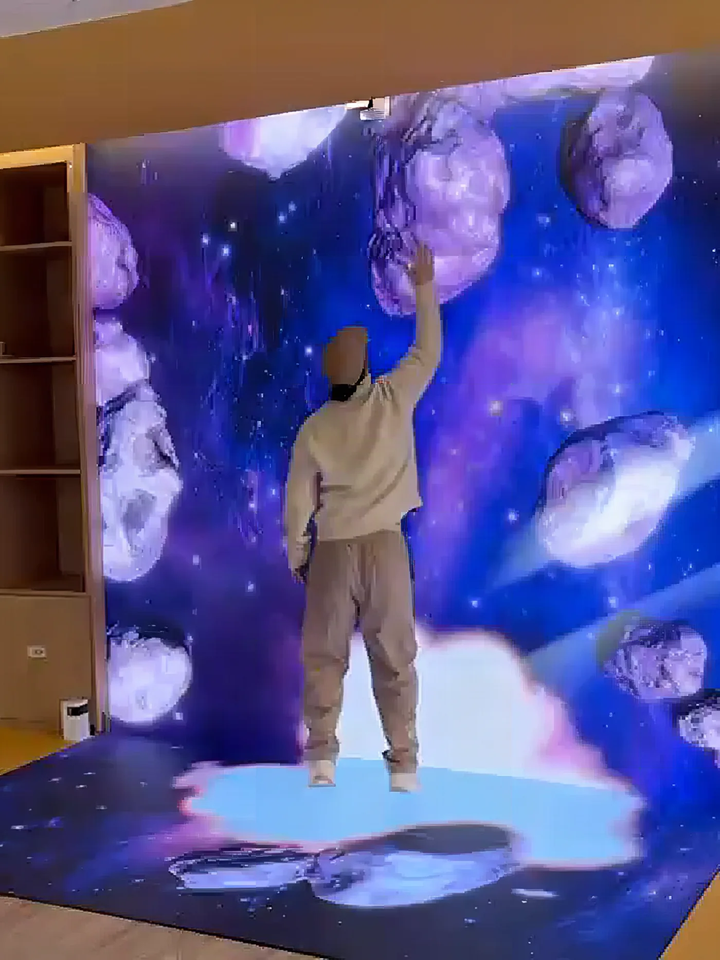 Interactive LED wall showing asteroids that drift away from the hands of a visitor