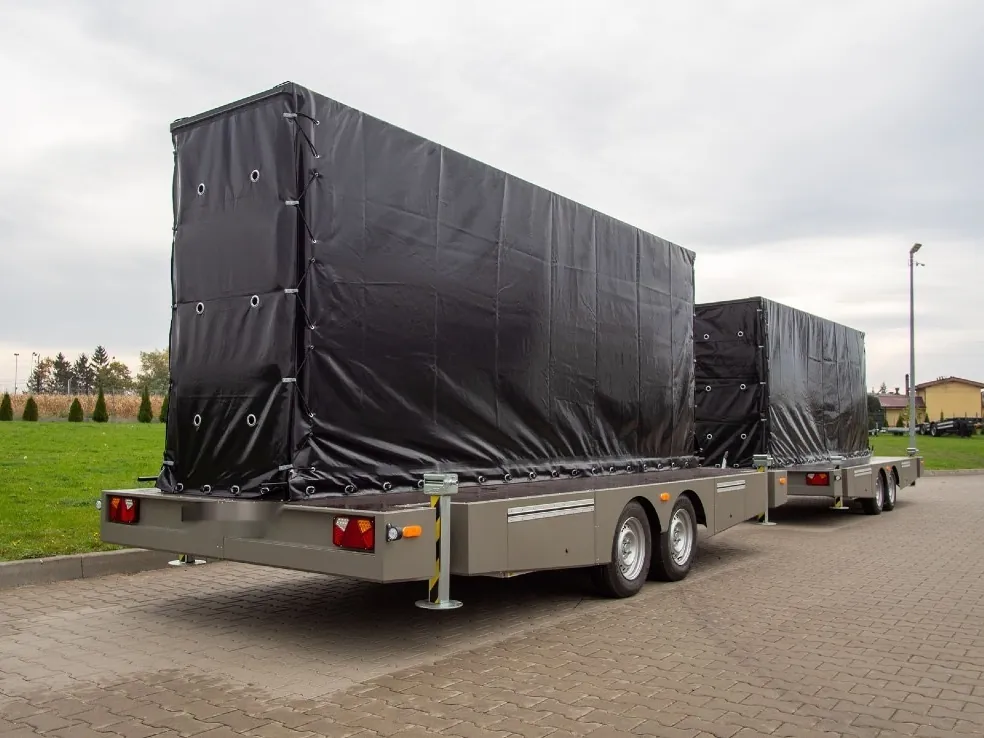 Two trailers carrying folded LED screens under black covers, ready for the road