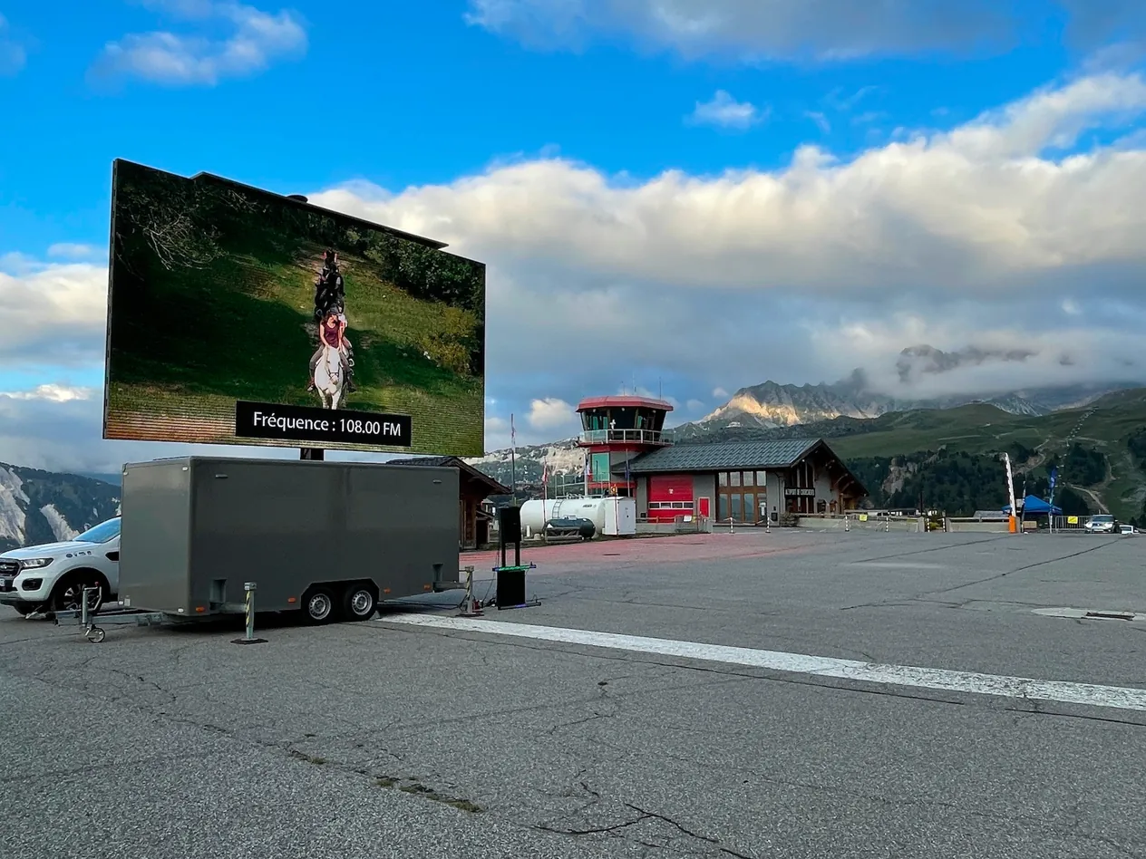28 m² LED trailer with its screen raised on a mountain airfield under a blue sky