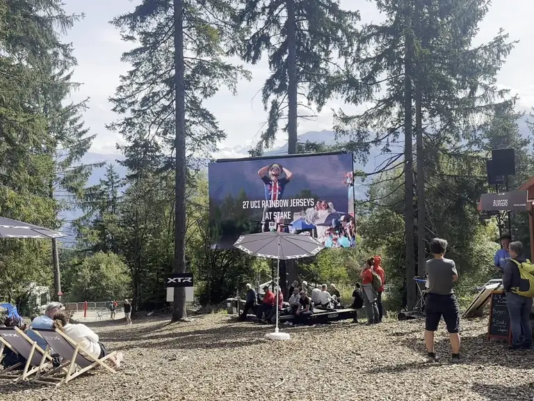 LED trailer screen above deckchairs beside a food stand at an outdoor sports event
