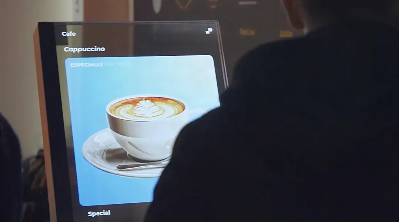 Un visiteur touche un écran OLED transparent pour parcourir son contenu