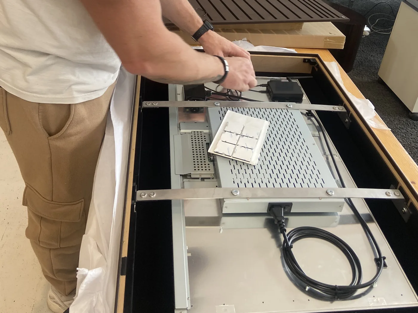 An open frame display being fitted into a piece of furniture