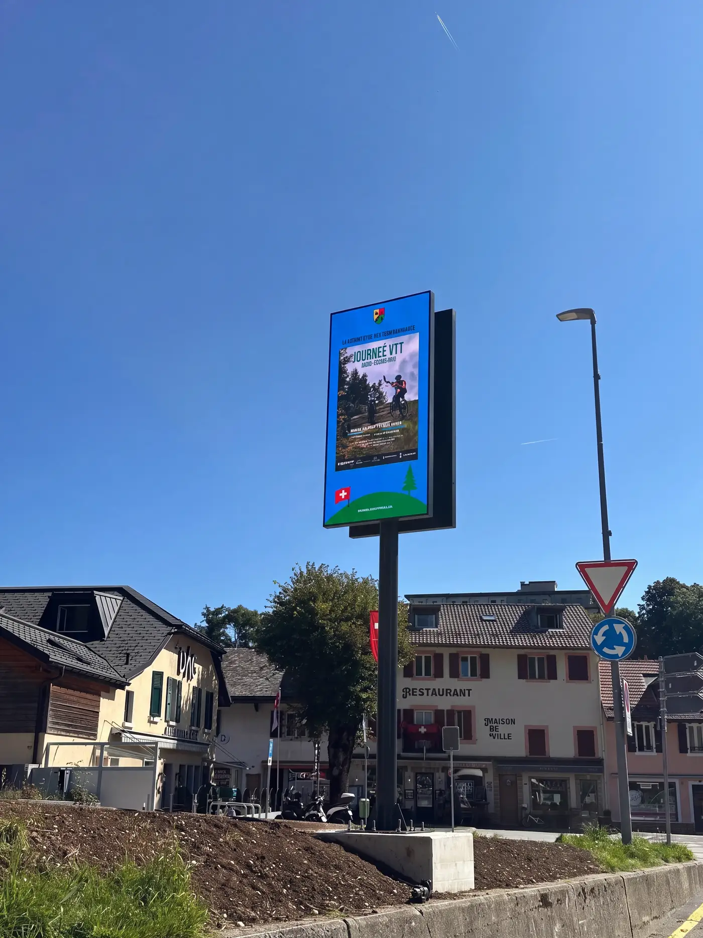 Outdoor LED screen on a mast in full daylight, the picture still bright and readable
