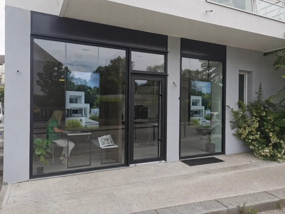 Bildschirm mit Immobilieninseraten im Schaufenster einer Immobilienagentur